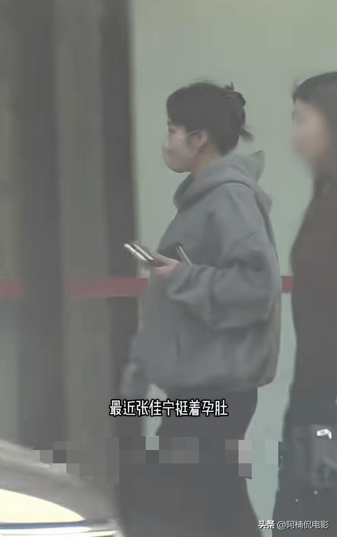 狗仔拍到张佳宁挺着孕肚和家人前往银行办事，素颜气色很好，下台阶时格外谨慎。从侧面