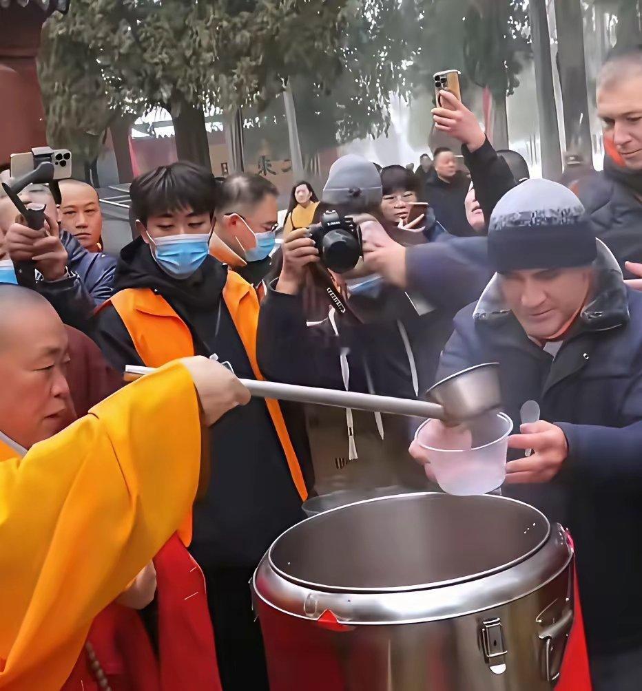 当年的释永信大师为香客们盛粥时的一幕四周围满摄像机跟拍 