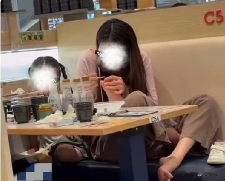 7月12日，江苏扬州一寿司店内，一名女子脱鞋盘腿坐在座椅上，还把孩子的双脚抬到餐