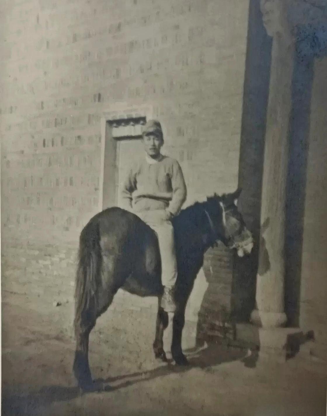 这是日军随军记者拍摄的一张照片，记录了日军在一建筑前倒骑骡子的照片。从建筑的风格