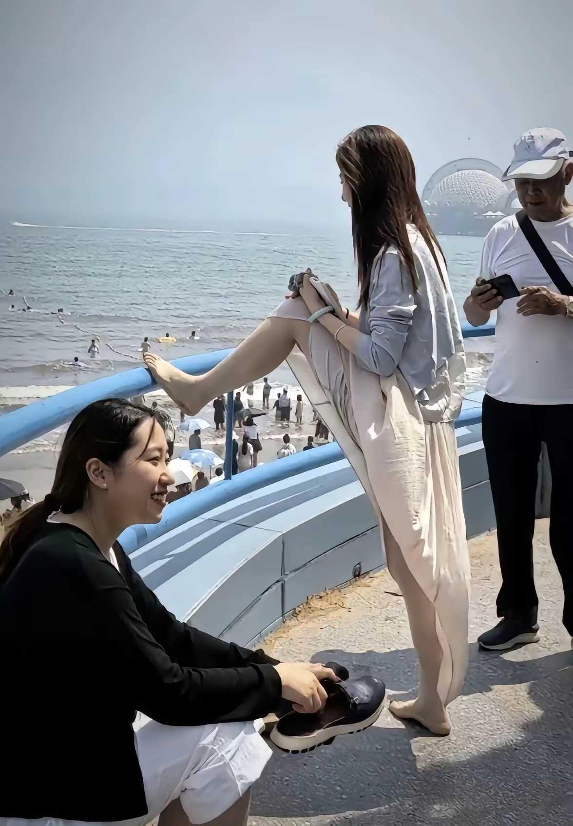 光看背影及侧颜，就能看出女子颜值很高，可她赤脚搭到护栏的这一动作 ，不太雅观哦，