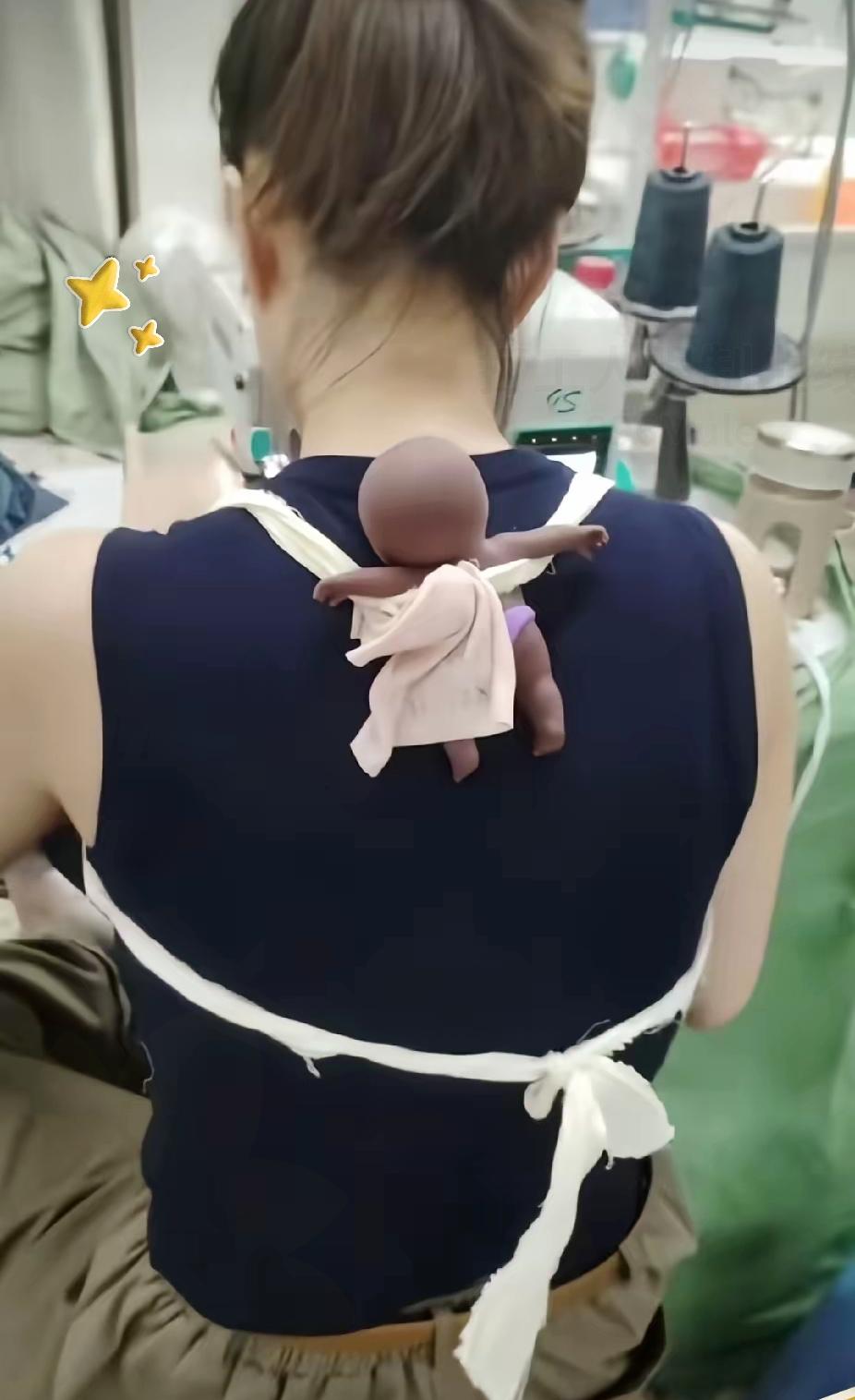 制衣车间里，一位女工身上总系着布带，背后还背着个玩偶，一开始只觉得奇怪，看清背后