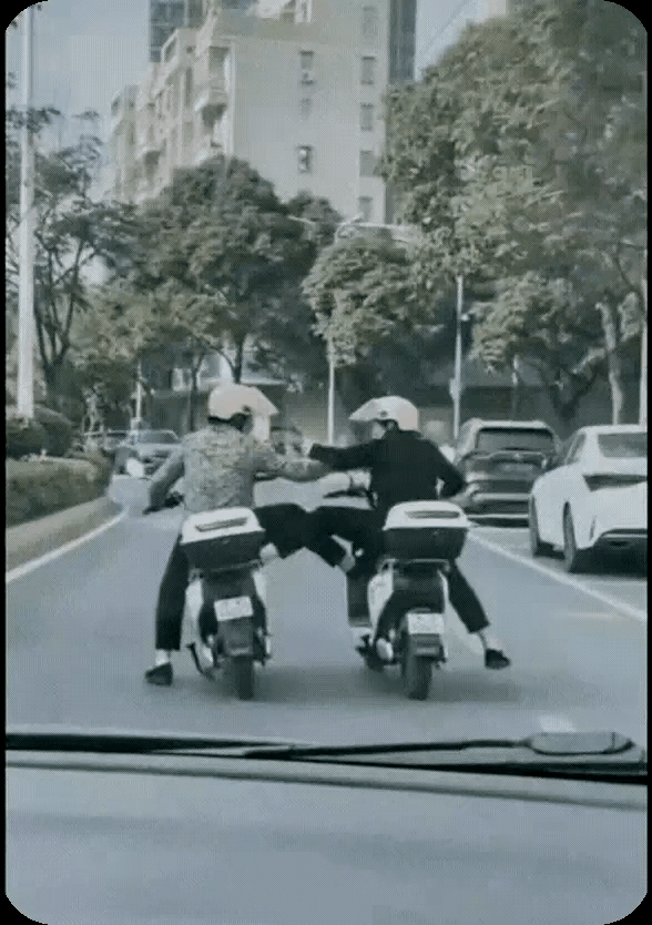 两个外卖哥，不顾自己的安全，骑着车竟然敢在马路上打打闹闹，你踢我一脚，我你一脚，