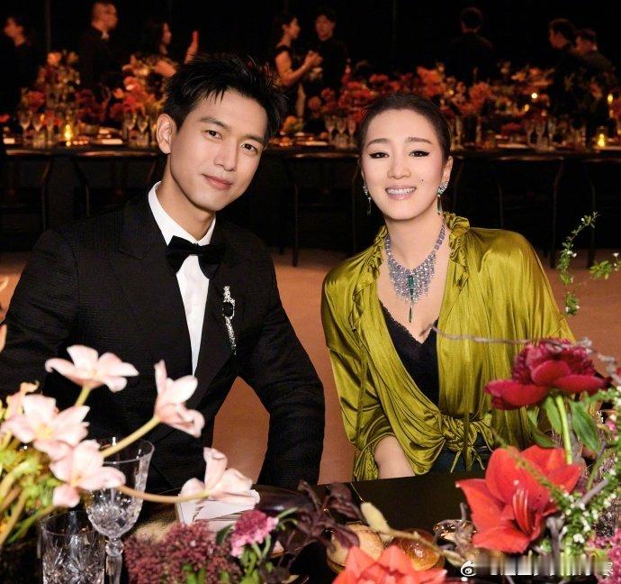 李现巩俐合照巩俐和李现合照巩俐和李现合照，他一身黑西装帅得干净利落，她穿绿丝绒配