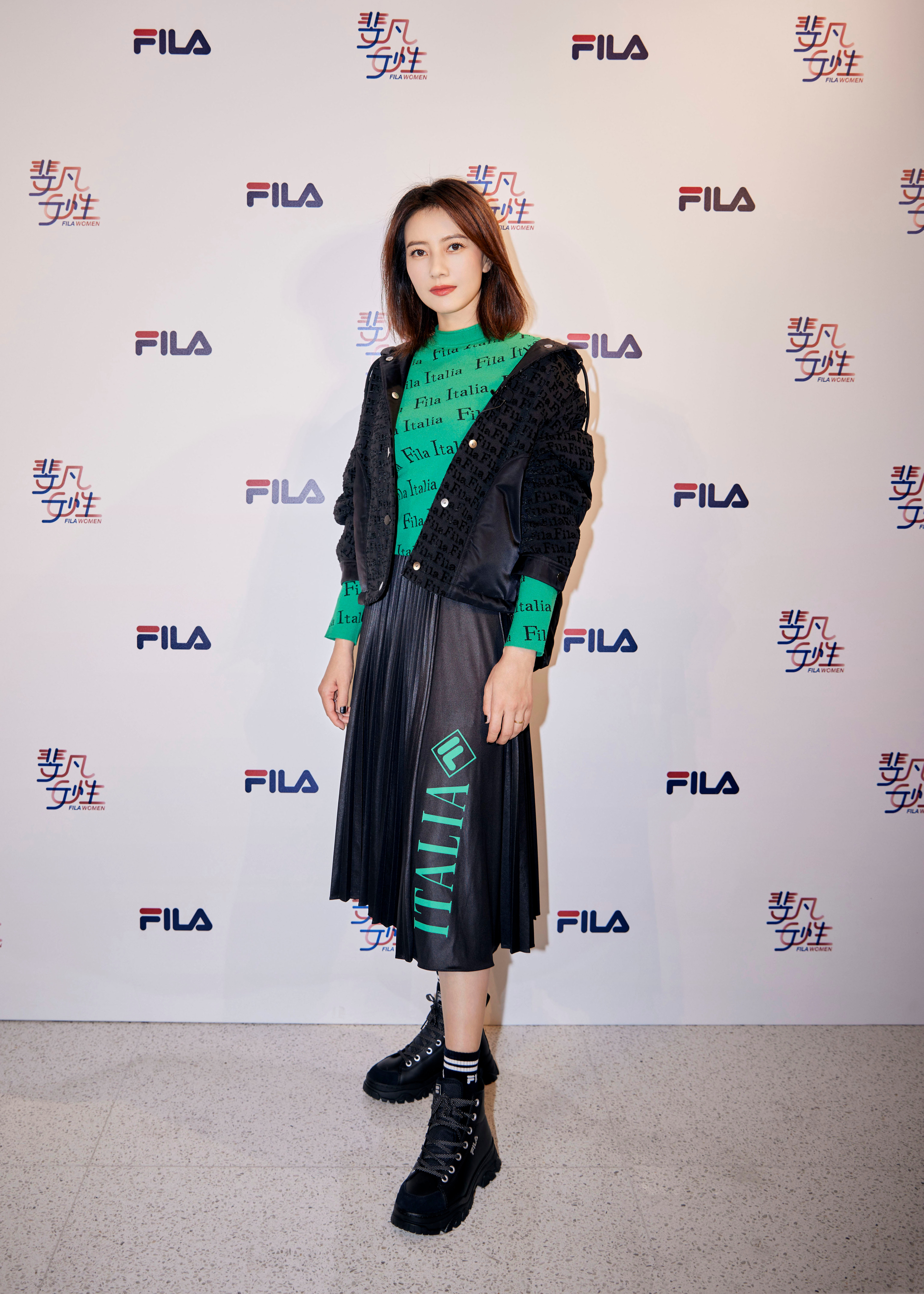 这套穿搭以黑绿撞色为核心，利落又有层次。黑色外套的暗纹设计增添了精致感，内搭的亮