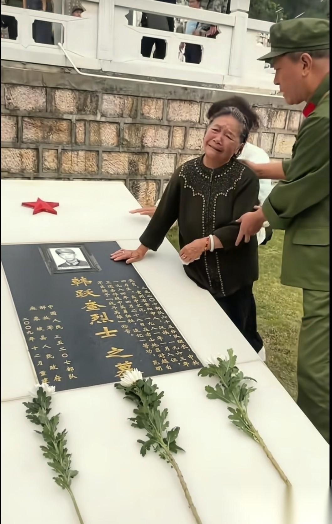 这是韩跃奎烈士的母亲，在儿子生前战友的陪同下来到了云南麻栗坡烈士陵园，看望长眠在