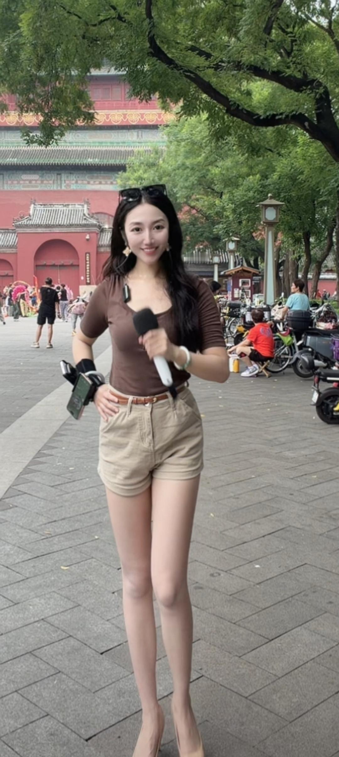 这位女士在街头拿着话筒。