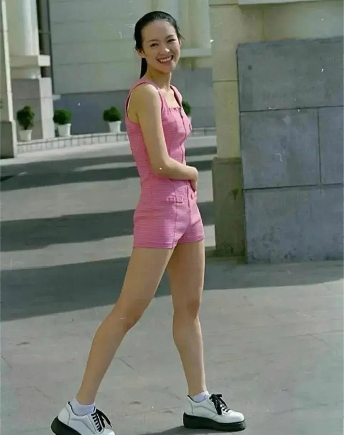 据说这是章子怡18岁上大学的时候，穿粉色连体裤，清纯娇俏，那时的她看起来青春有活