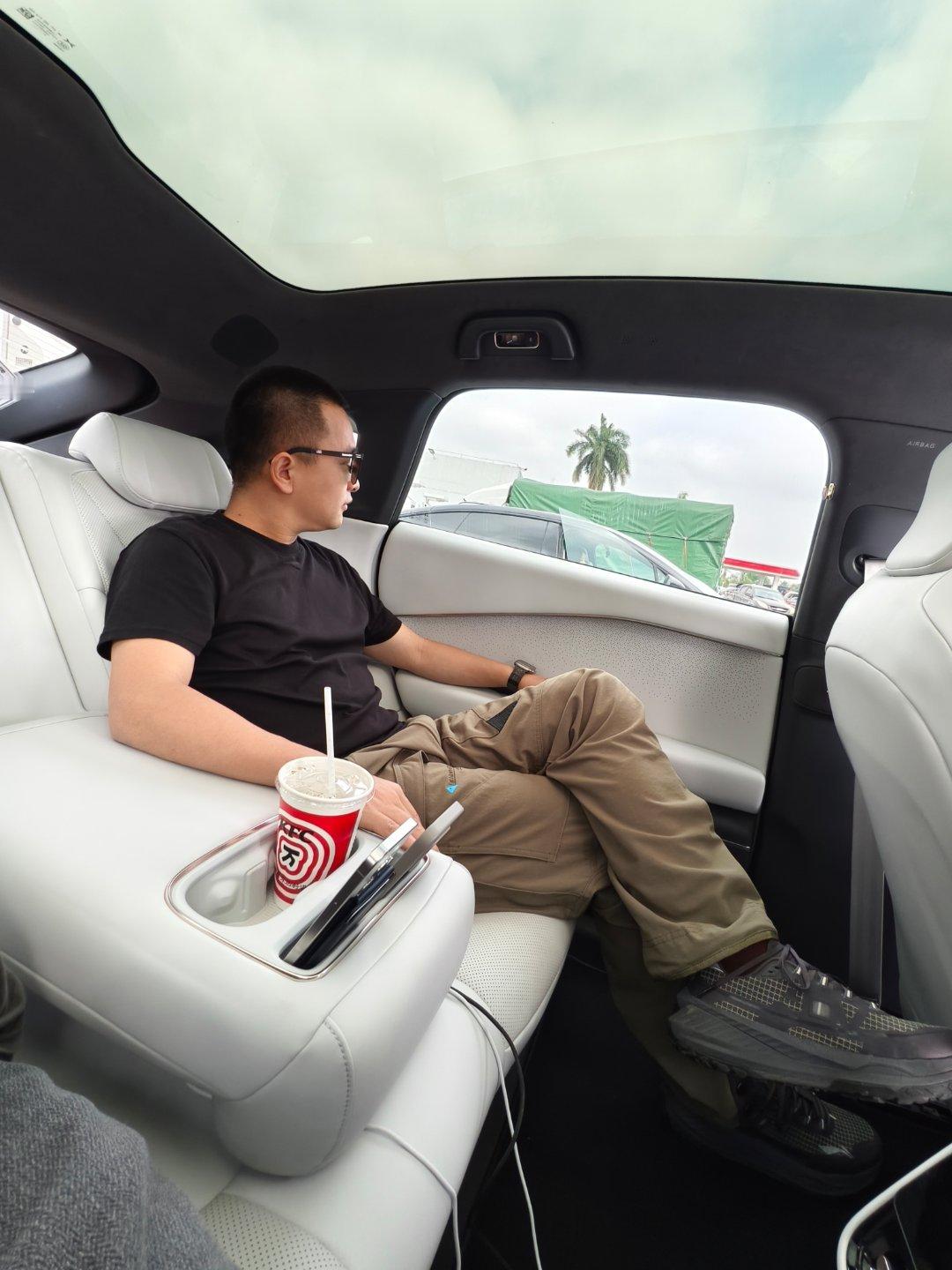 别说，小鹏 P7+这二排空间是真可以。另外，这个能插手机的二排扶手箱设计很方便。