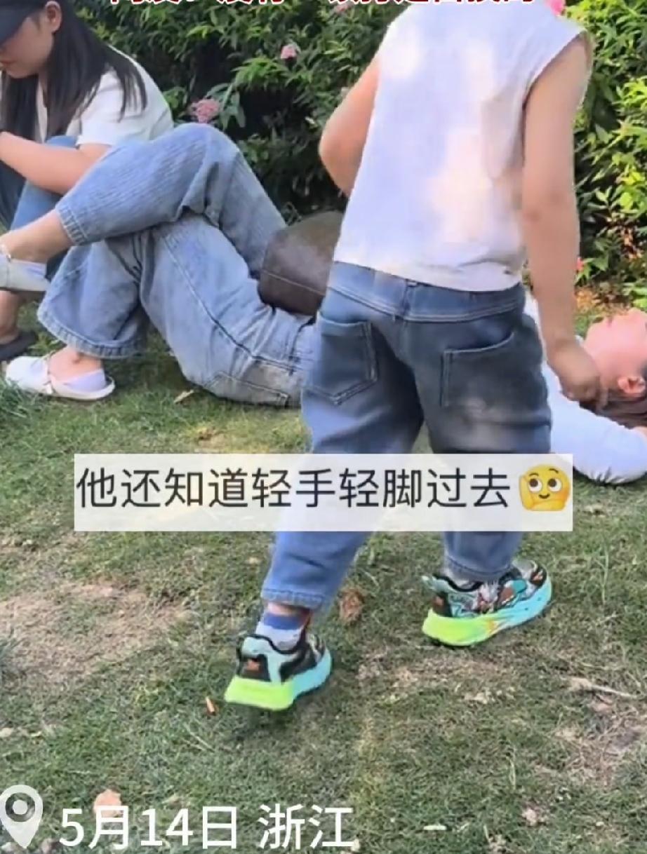 5月14日，浙江。一家亲子游公园。妈妈累了，躺在树荫下面的的草地上休息。妈妈眯着