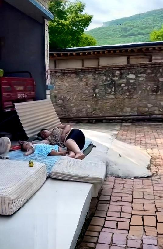 女子带孩子回娘家，午睡出门看见母亲和娃躺在院子阴凉处午休。
她自己平时带娃样样精