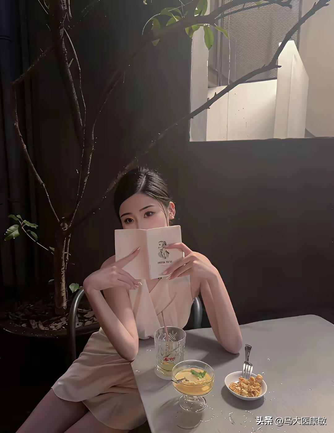 一位女生在咖啡馆里看书，旁边有饮料和点心。