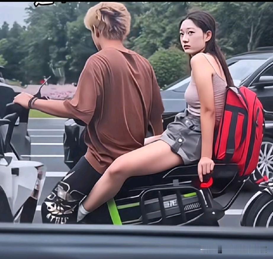 等红灯时，坐在摩托车上的女孩不由得多看了旁边几眼迈巴赫，好像有某种外力促使他要远