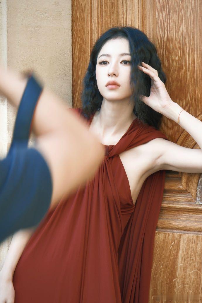 周雨彤羊毛卷酒红长裙 酒红色垂褶长裙把身材线条展现得很好，垂褶借由重力将量感赋予