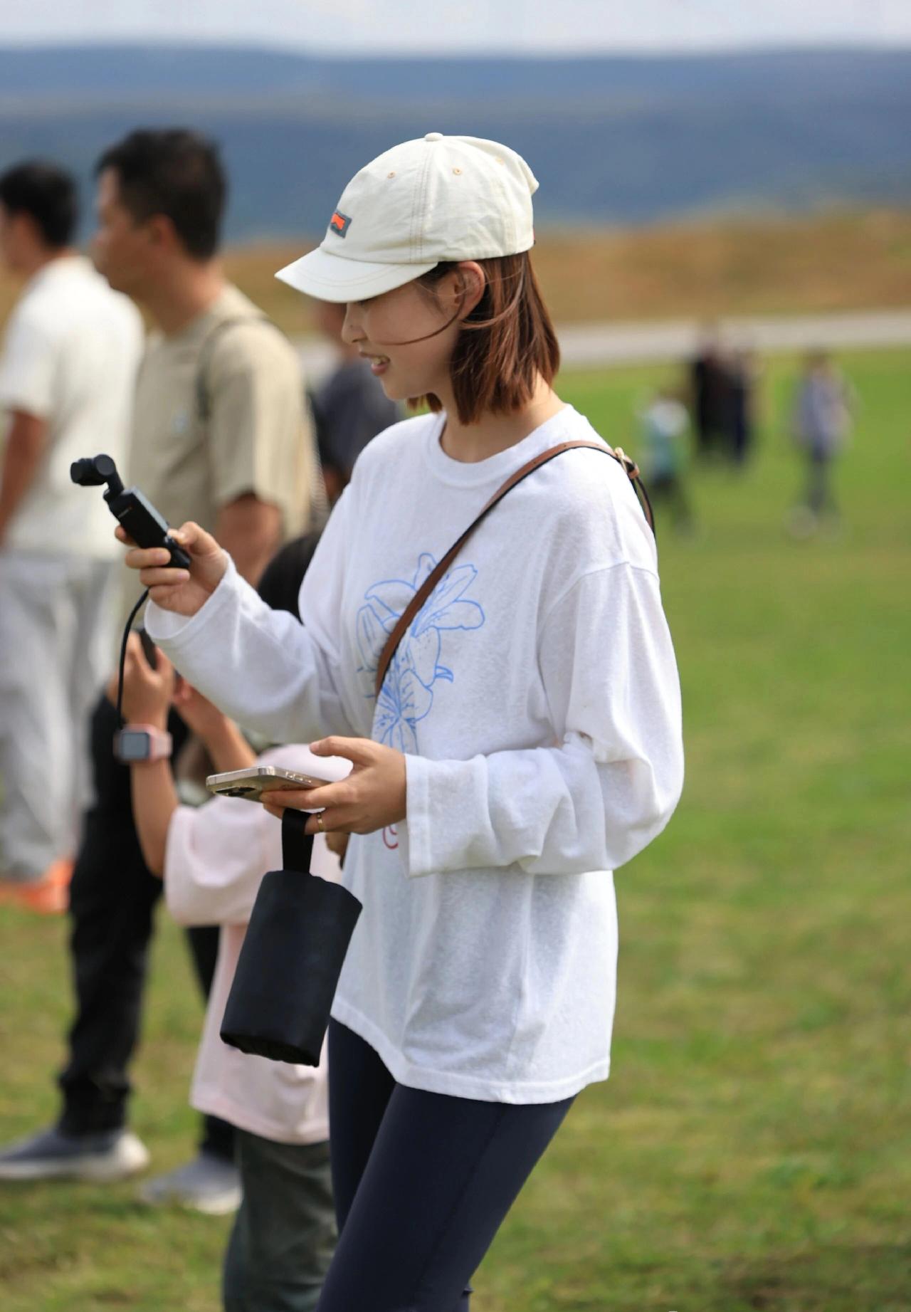 春天来了，到处都是美景，到处都是秀色》白衣少女立芳草，手持相机记芳华。一眼沦陷的