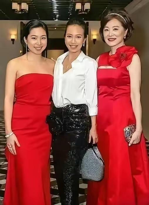 三位美女穿着红色礼服，站在一起拍照。女儿不像妈妈👩🏻，很幸福🥰红装美人照