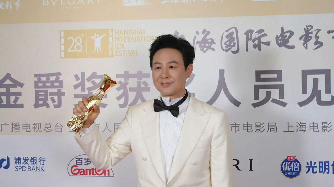 第28届上海国际电影节金爵奖最佳男演员，属于张颂文。一身利落白西装，手握沉甸甸的
