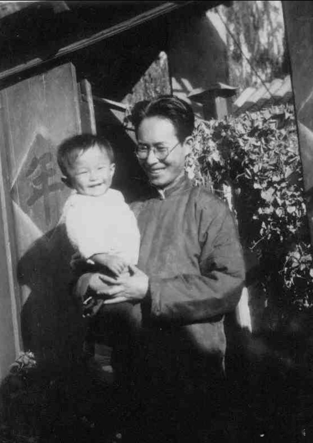 1935年，著名作家沈从文抱着长子沈龙朱站在大门前的温馨瞬间。这张照片不仅记录了