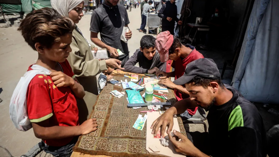 在加沙的集市上，修补破损纸币已成为一门生意。由于现金严重短缺，且银行常常无钱可取