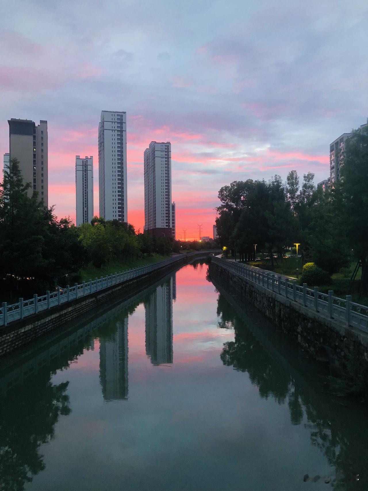 夏日生活打卡季夏日的傍晚格外温柔，小河静静流淌，漫天晚霞染成粉橘色，天空的美景完