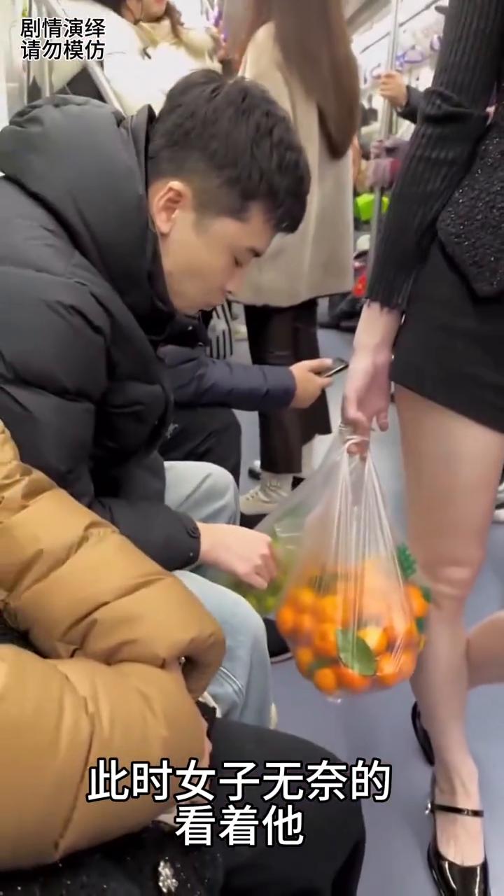 女子提着水果乘坐地铁，这时旁边坐的男子吃她的水果，这时她还不知道女子一直盯着他。
