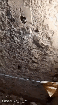 一名乌军从掩体俯瞰下面的房屋，遭到俄军FAB航弹轰炸后，一片浓烟滚滚，造成了严重