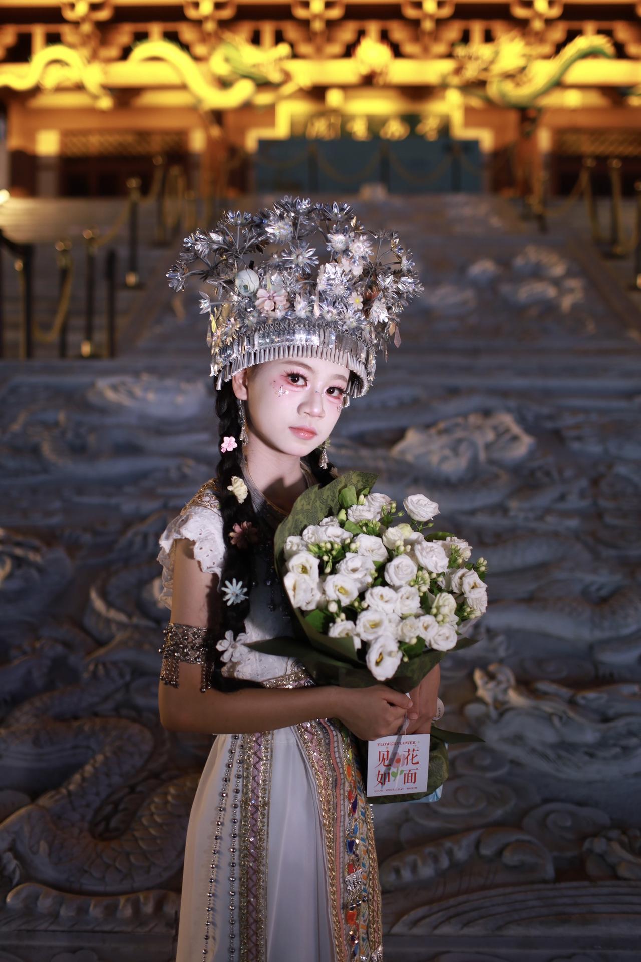 苗妹手执一束白玫瑰🌹来到龙城阁打卡。可惜脸上没表情^^