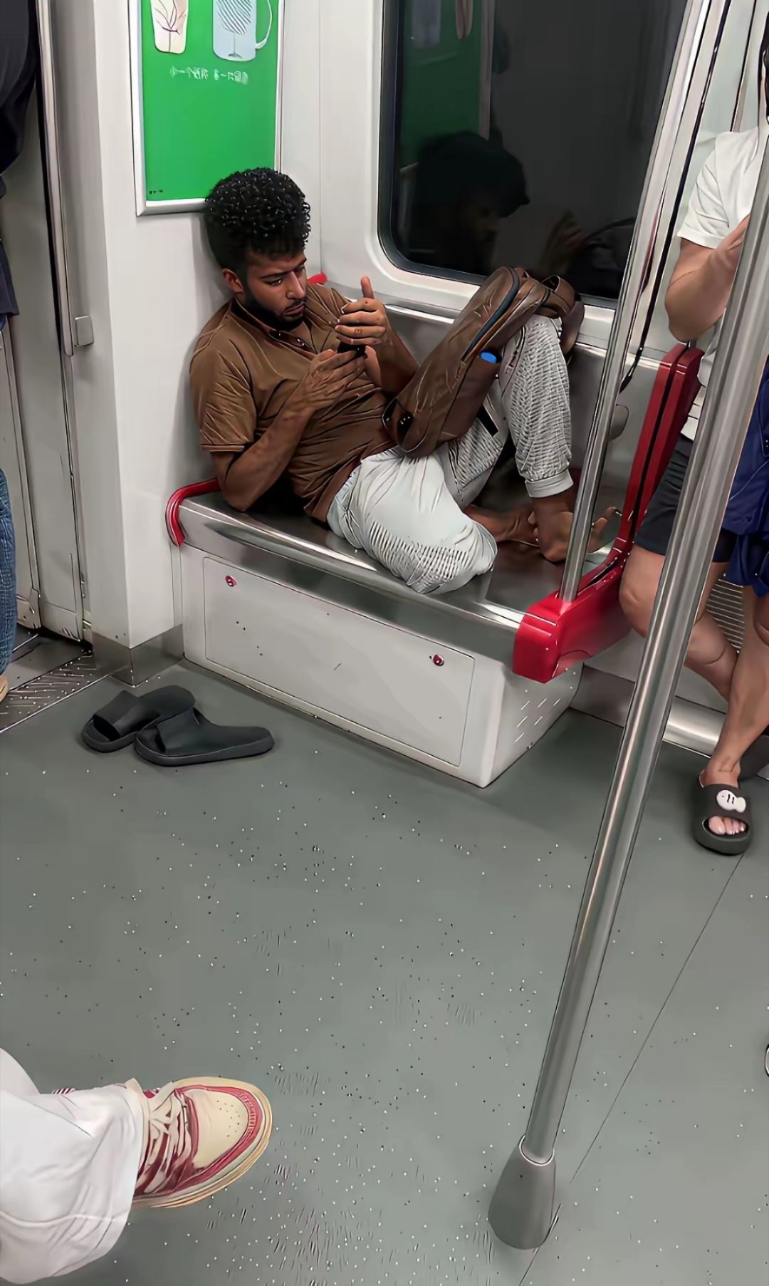 这个印度人坐地铁一直不下车，大概是为了乘凉？一个人占了二个位置，还把脏脚踩在座位