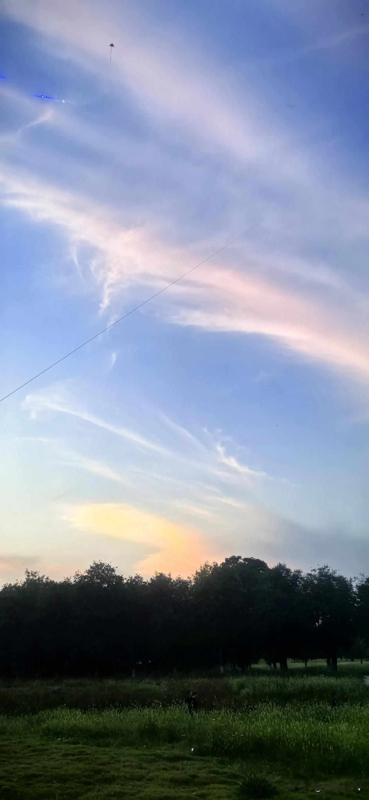 7月9日暮色把大明宫遗址公园浸成了半透明的诗。
天的蓝从林梢往云深处慢慢淡去，那