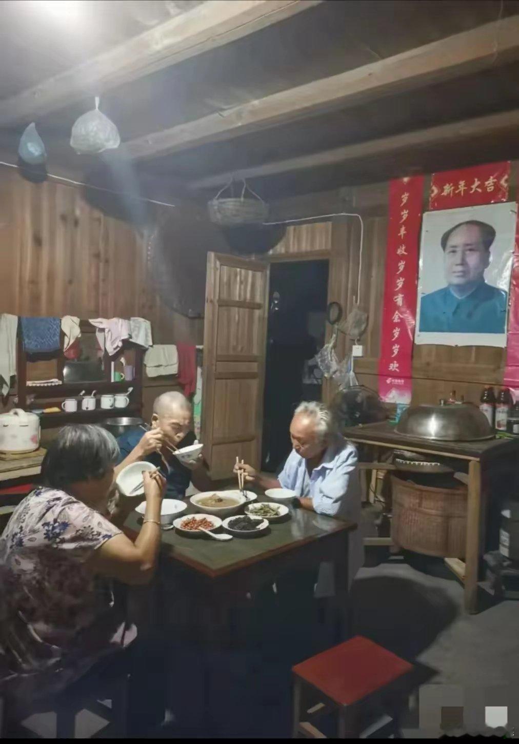 一张随手拍竟能燃爆全网，日点赞量4·3万。木质老屋，墙上挂着毛主席像，旁边三位安
