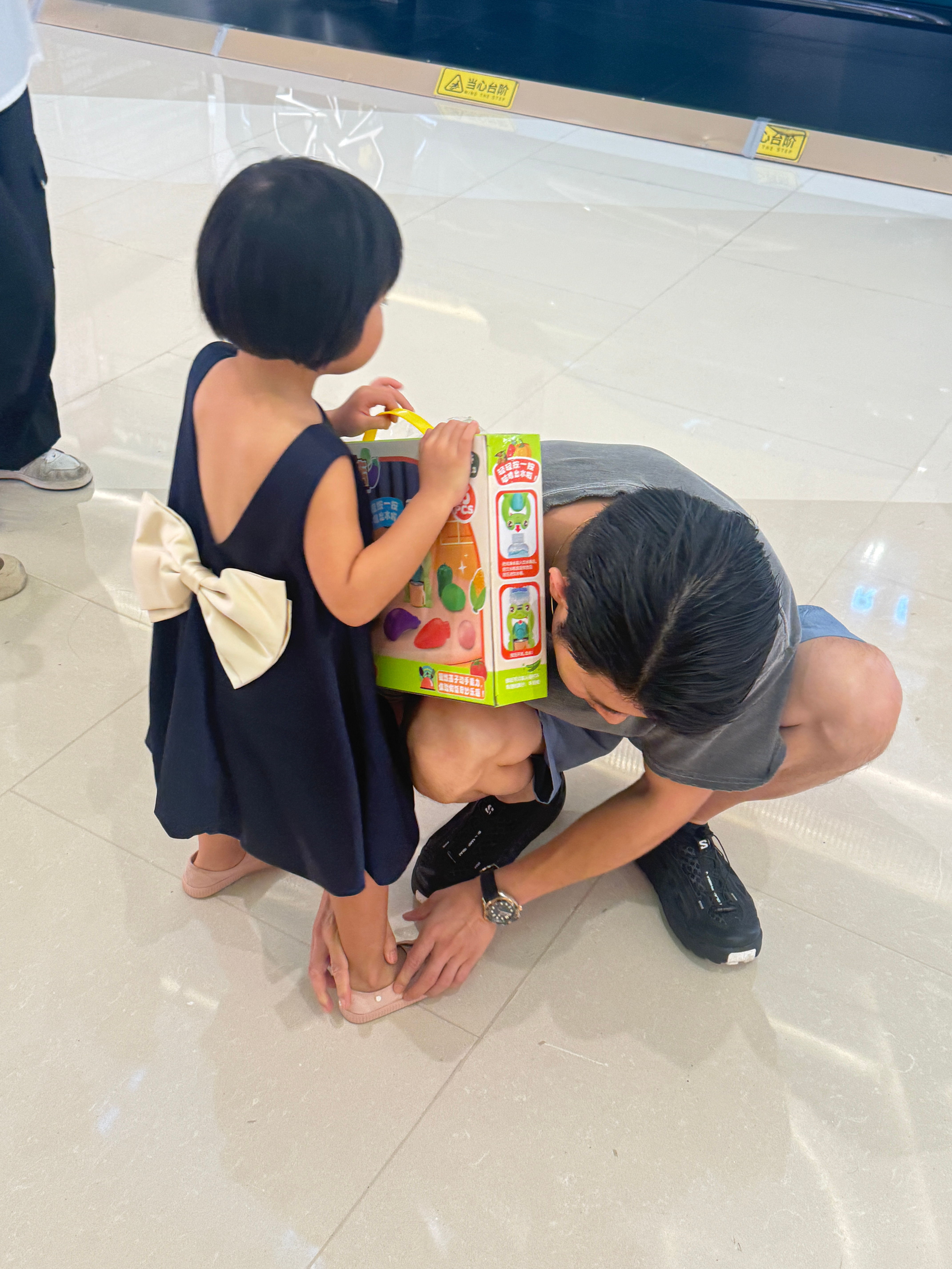 今天吃完午饭我们在商场闲逛，一位大姐提着这盒玩具上来问我们要不要报舞蹈和画画体验