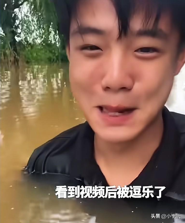 7月13日，河北廊坊，暴雨过后，一小伙趟着积水去烧烤店上班，路上的积水快淹过脖子