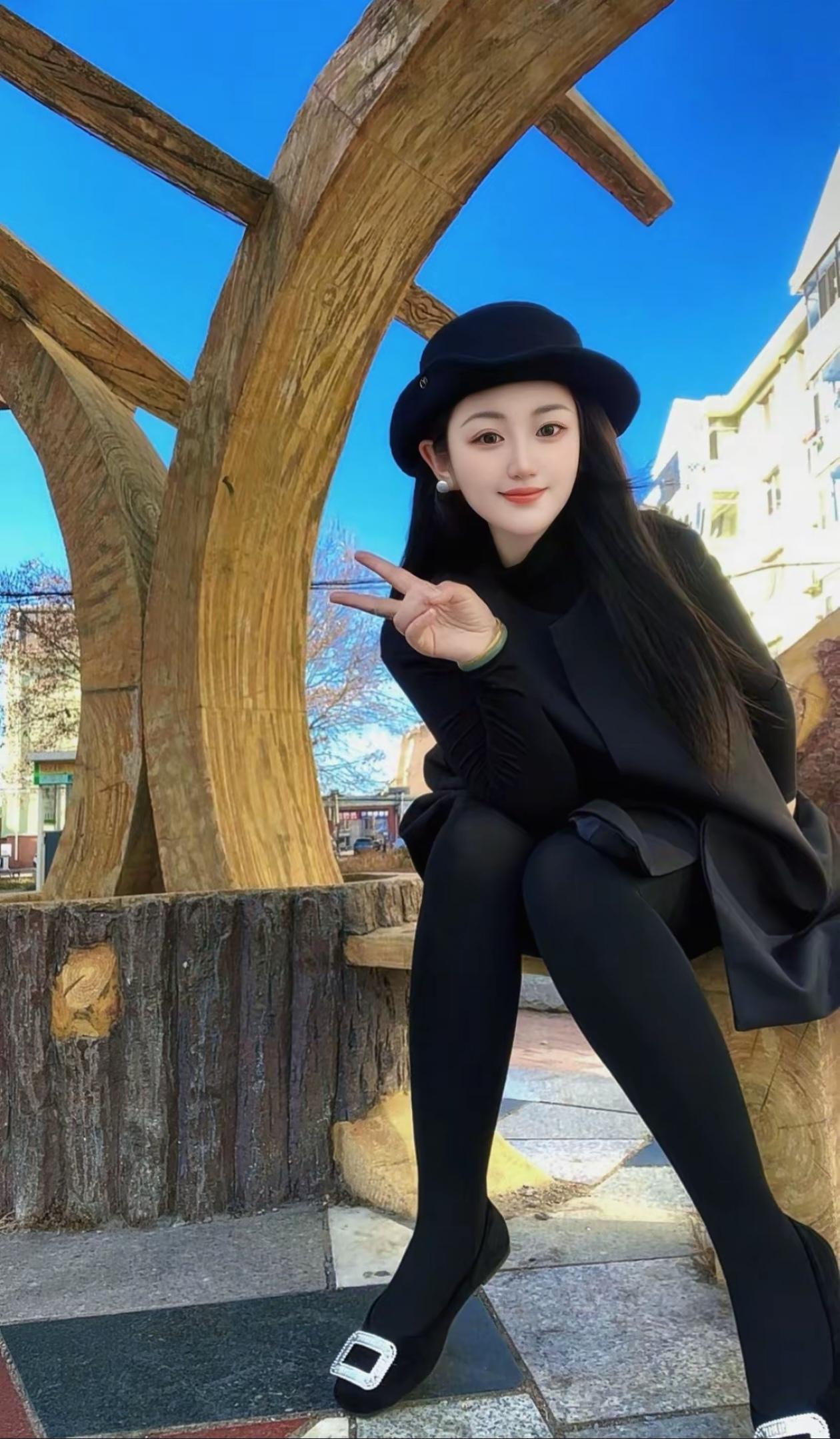 黑衣少女在木制长椅上比V，阳光明媚的一天