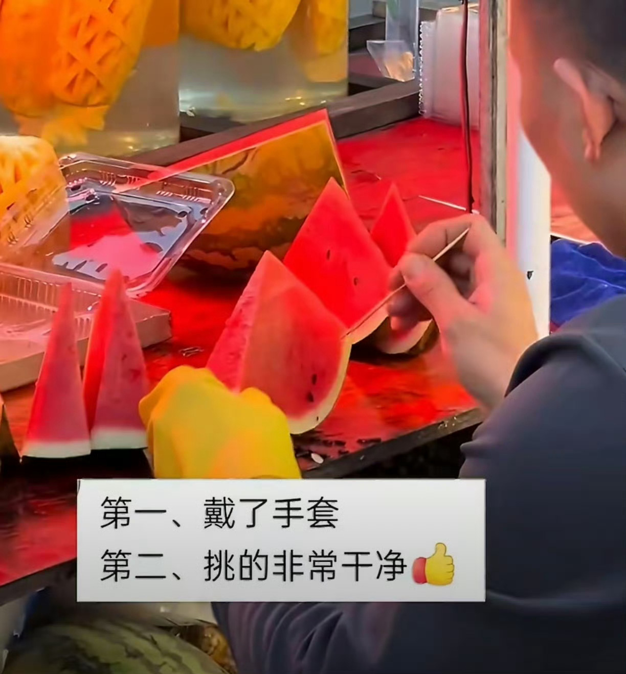 西瓜摊老板戴手套用牙签挑瓜籽估计很快这家老板的摊位前就要排起长队了！ 