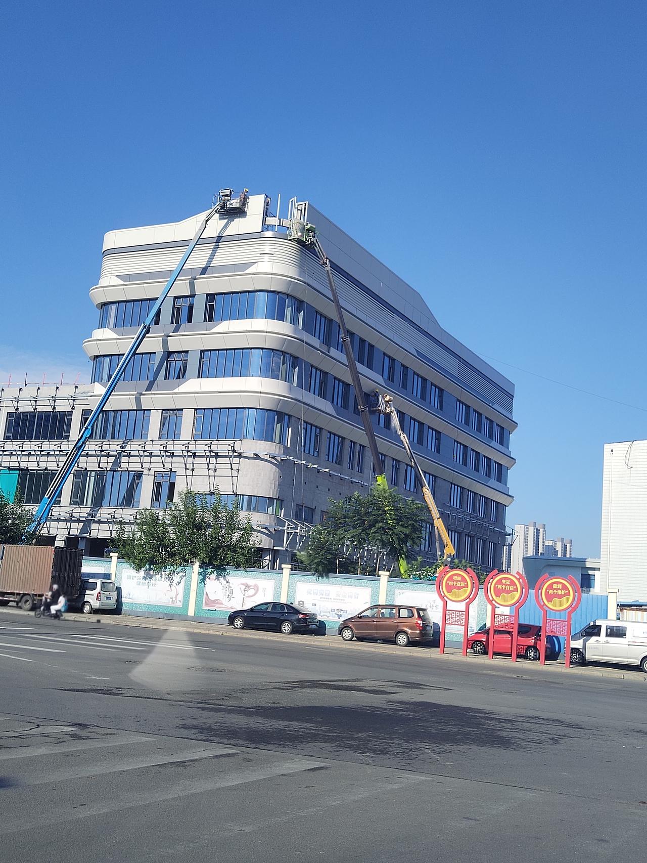 德州市德城区三八西路铁路涵洞办公楼两台吊车在施工， 有好几个人紧张施工中， 办公