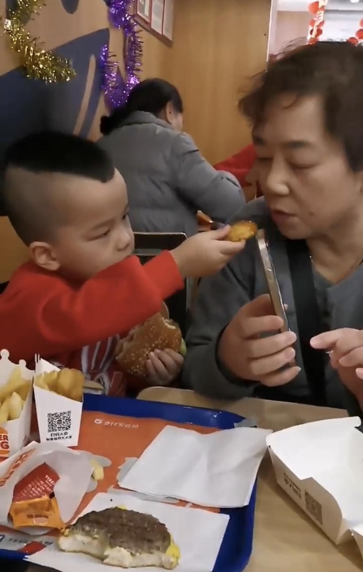 这一幕直接戳中泪点！
刹那间被爱暖到心窝了！小孙孙喂奶奶吃汉堡的画面，直接把温柔