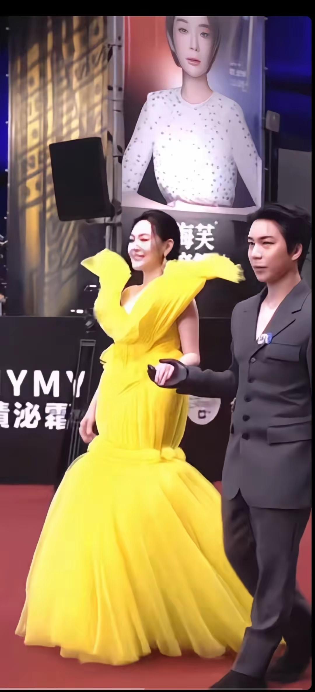 小S这红毯造型也太敢了吧！一身亮黄色礼服像展开翅膀的火烈鸟，V领开到腰+蓬松大裙
