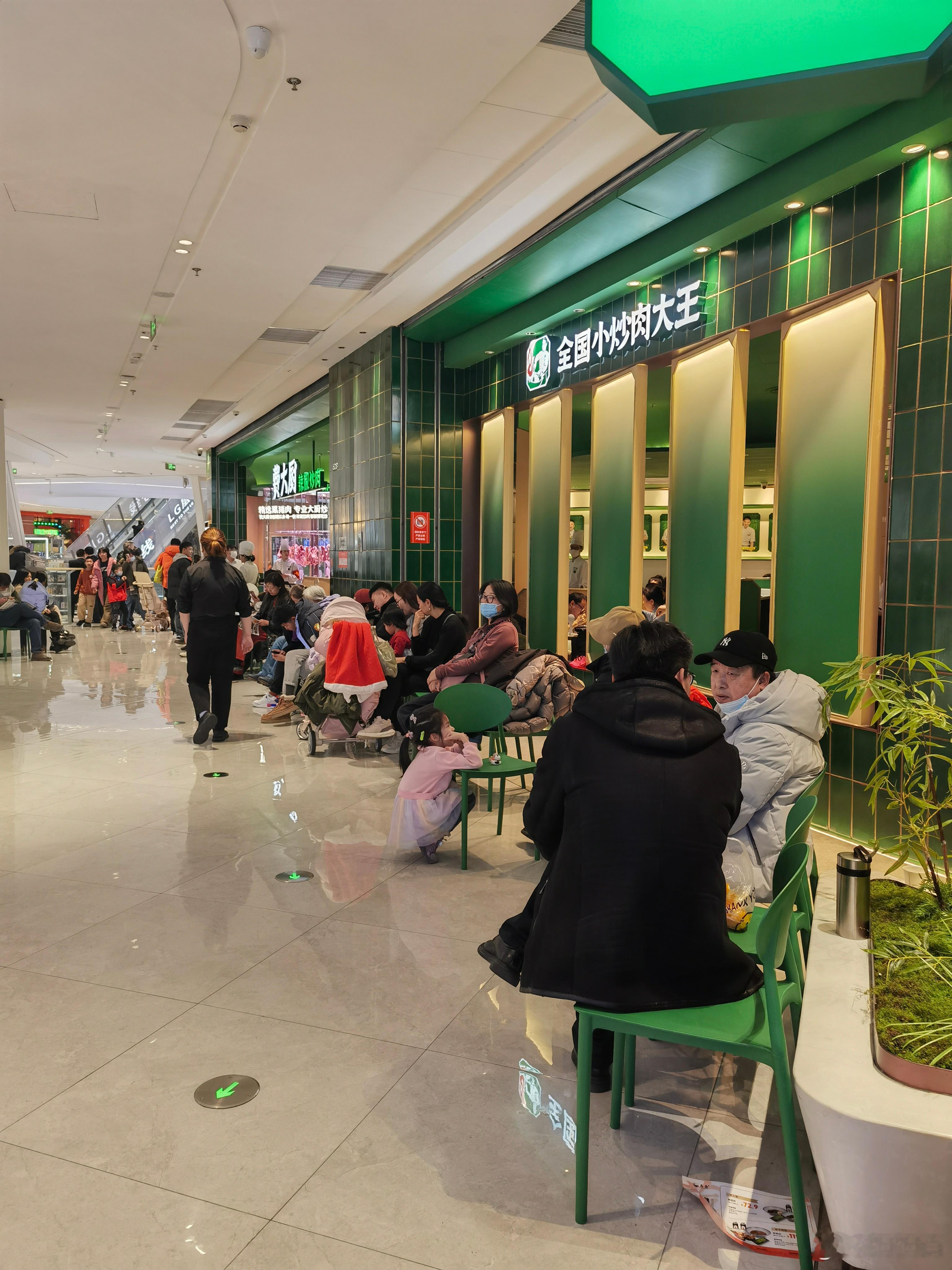 商场里面饭店排队的人不少。 