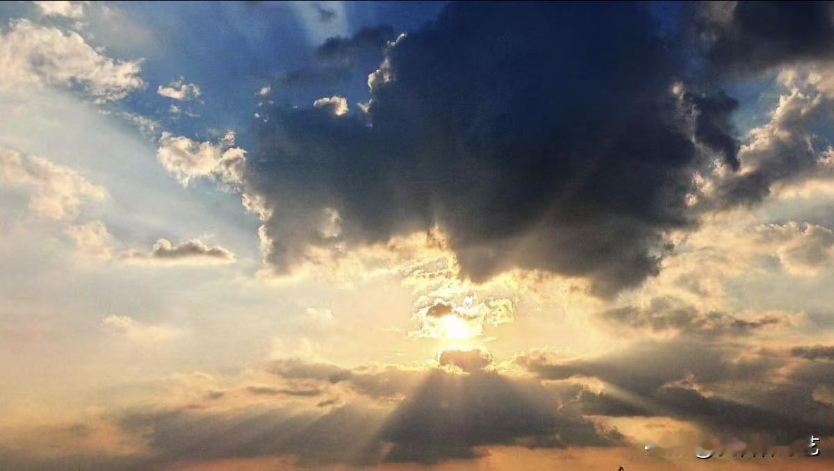 秋日生活打卡季云层叠涌，落日自云隙间倾洒万丈丁达尔光。一边沉云如墨，一边霞光漫染