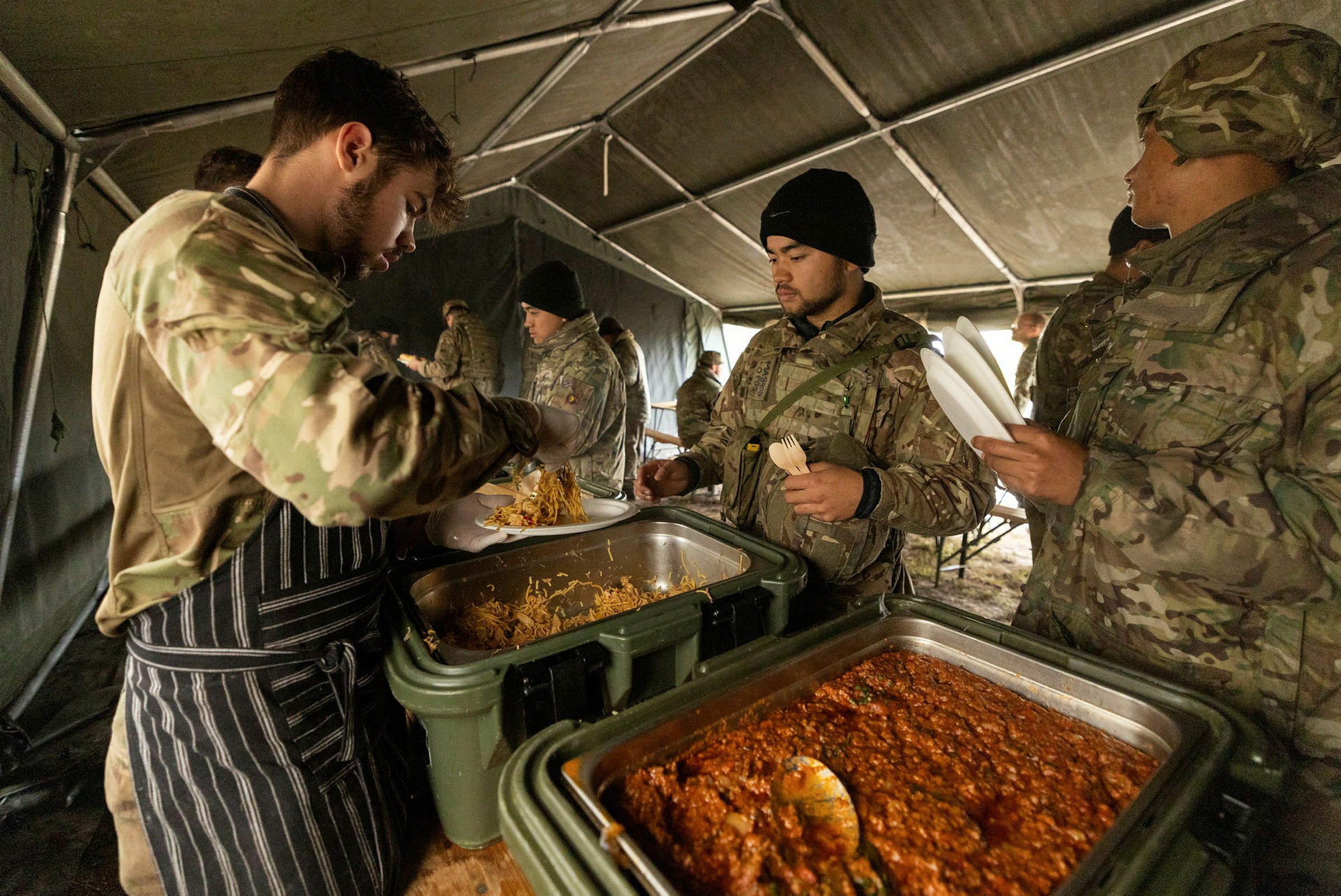 隶属于英国陆军第9团的二等兵麦克法登是一名厨师，他正在拉脱维亚的一个野战厨房为参