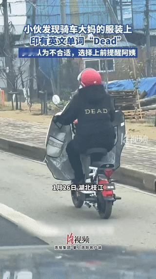 湖北，一小伙开车时，发现路边有一位骑电动车的阿姨，她衣服背后的英文单词写的是“D