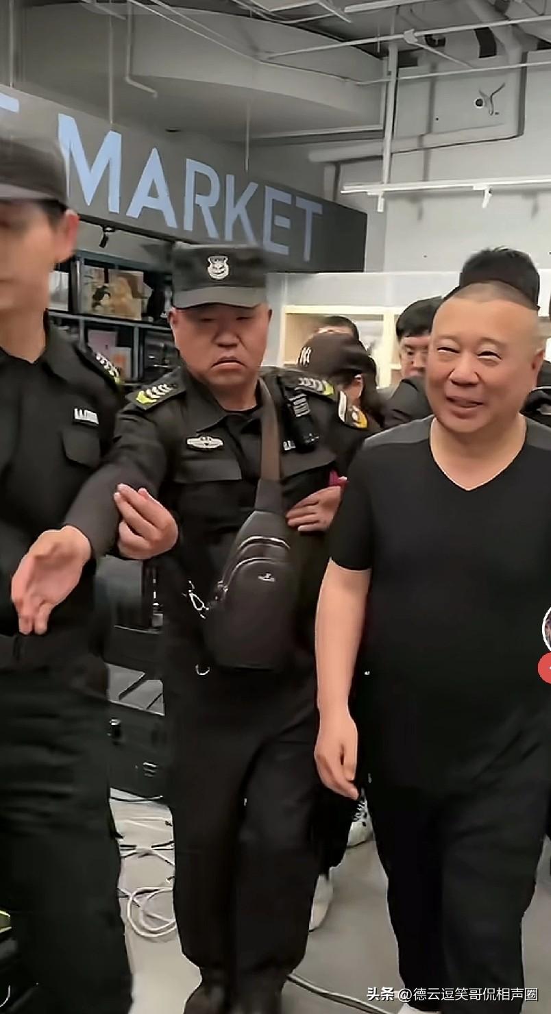 天津德云社演出时，郭德纲缓缓走向剧场。剧场旁边围着一大群保安，想要和他合影、求签