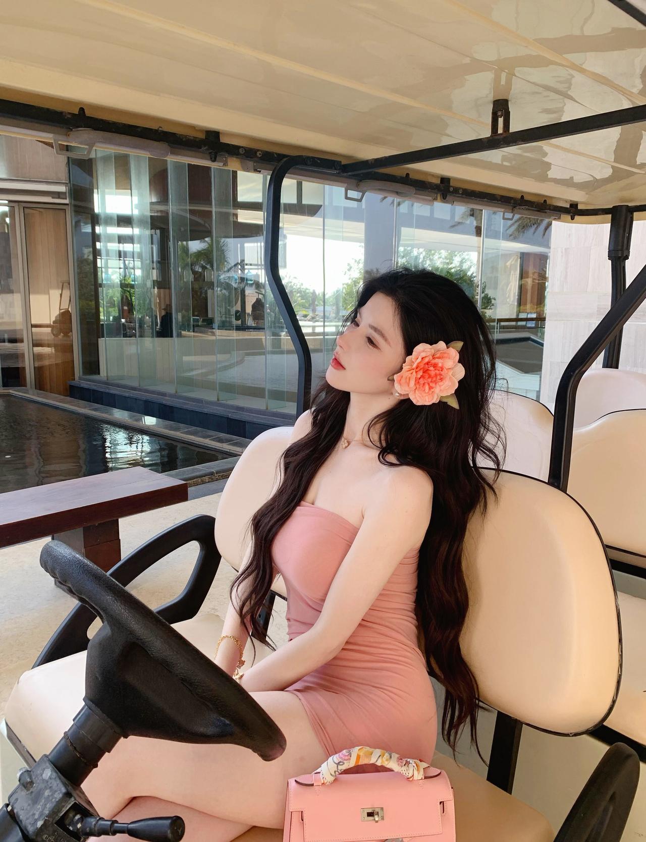 《旅畔春纱》
粉裙轻软趁风斜，
鬓畔簪花照落霞。
椰树连天浮碧海，
一襟清梦在天