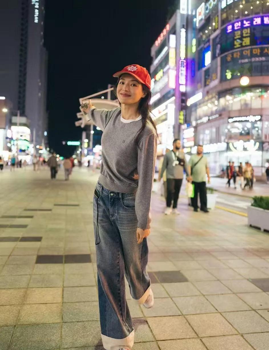 舒淇的冻龄松弛感赢麻了✨
 
灰色针织衫+翻边牛仔裤+红帽，随性又减龄，笑容甜得