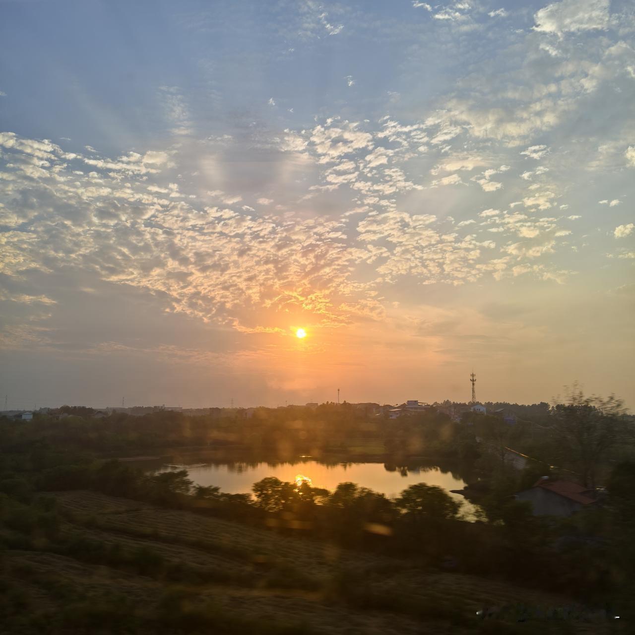 高铁车窗外的一幕实在太美了。坐高铁返程，闭目养神后睁开眼望向车窗外，被外面的落日