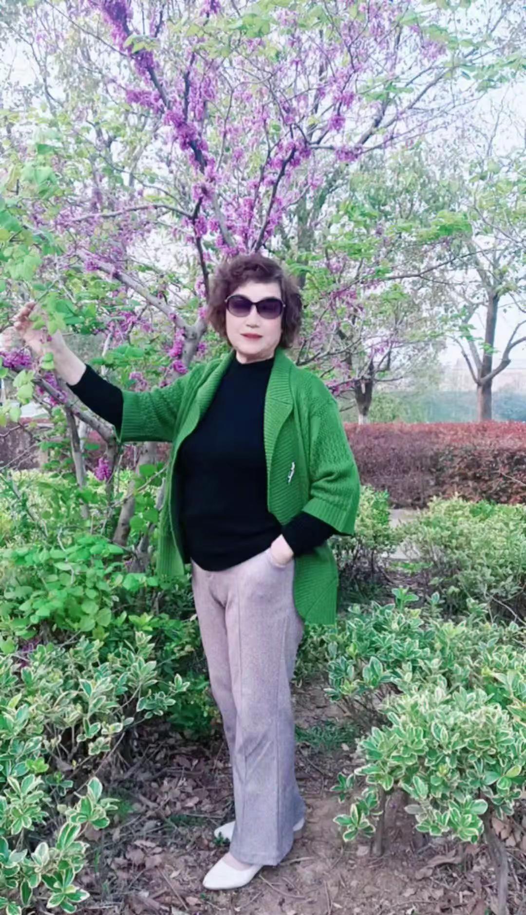 春风拂过紫荆花枝，花瓣轻落如雨，我站在花影里，像一幅被时光轻轻铺开的画。绿色外套