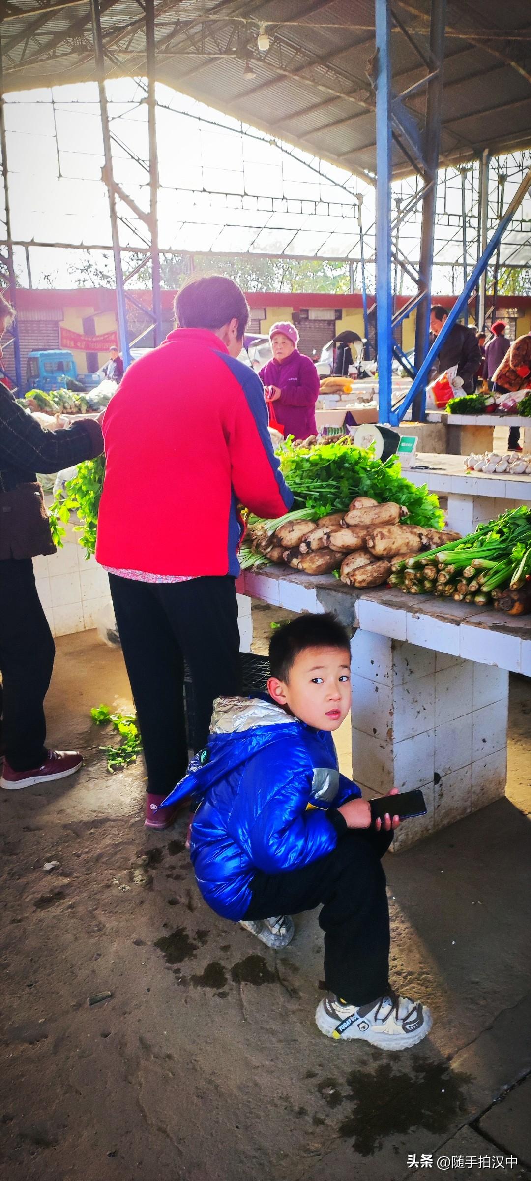 冬日生活打卡季趁着奶奶挑把芹菜的功夫，男孩耍一会手机，还机敏的张望一下四周。咋得