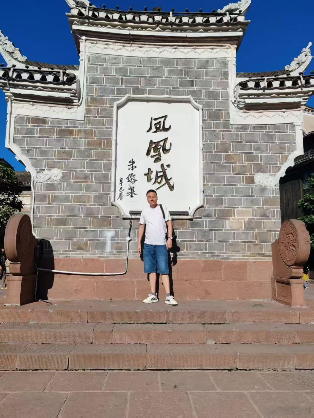 去年在湘西凤凰旅游时，有幸与朱公题的“凤凰城”三字合影。如今斯人已去，题词长存！