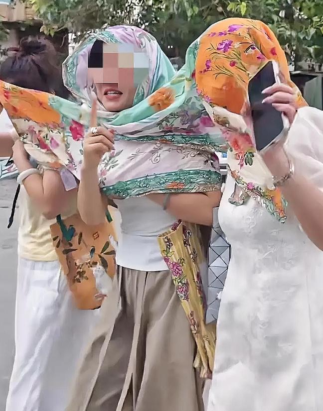 三名中国女子在巴勒斯坦街头，因为其中 2 人忘了带裹头的头巾，只得三人共用一条围