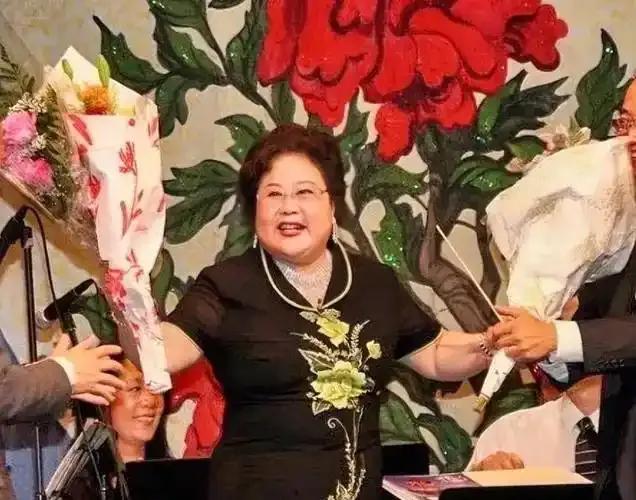 曾有演员被指“吃里爬外”，她携30名演员留美发展，引发“永不回国”争议。如今花甲